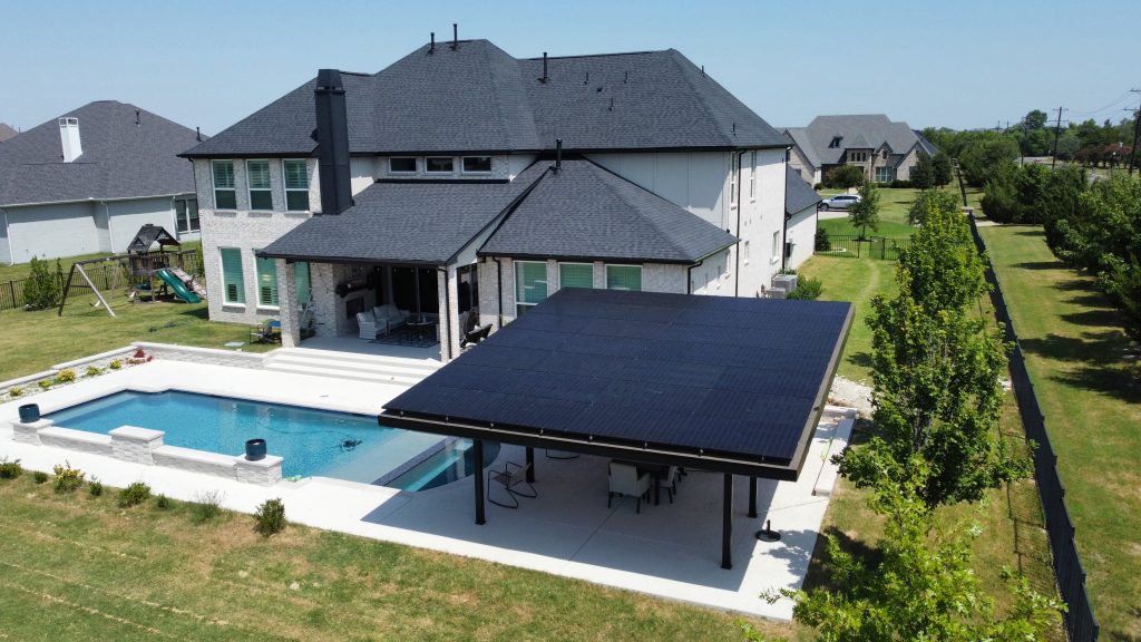 Solar mounted on Steel Patio Structure with modified bitumen roof built by Texas IE Solar Roofing and Construction in Parker, Texas — drone shot from above showing house, yard, and pool in the background